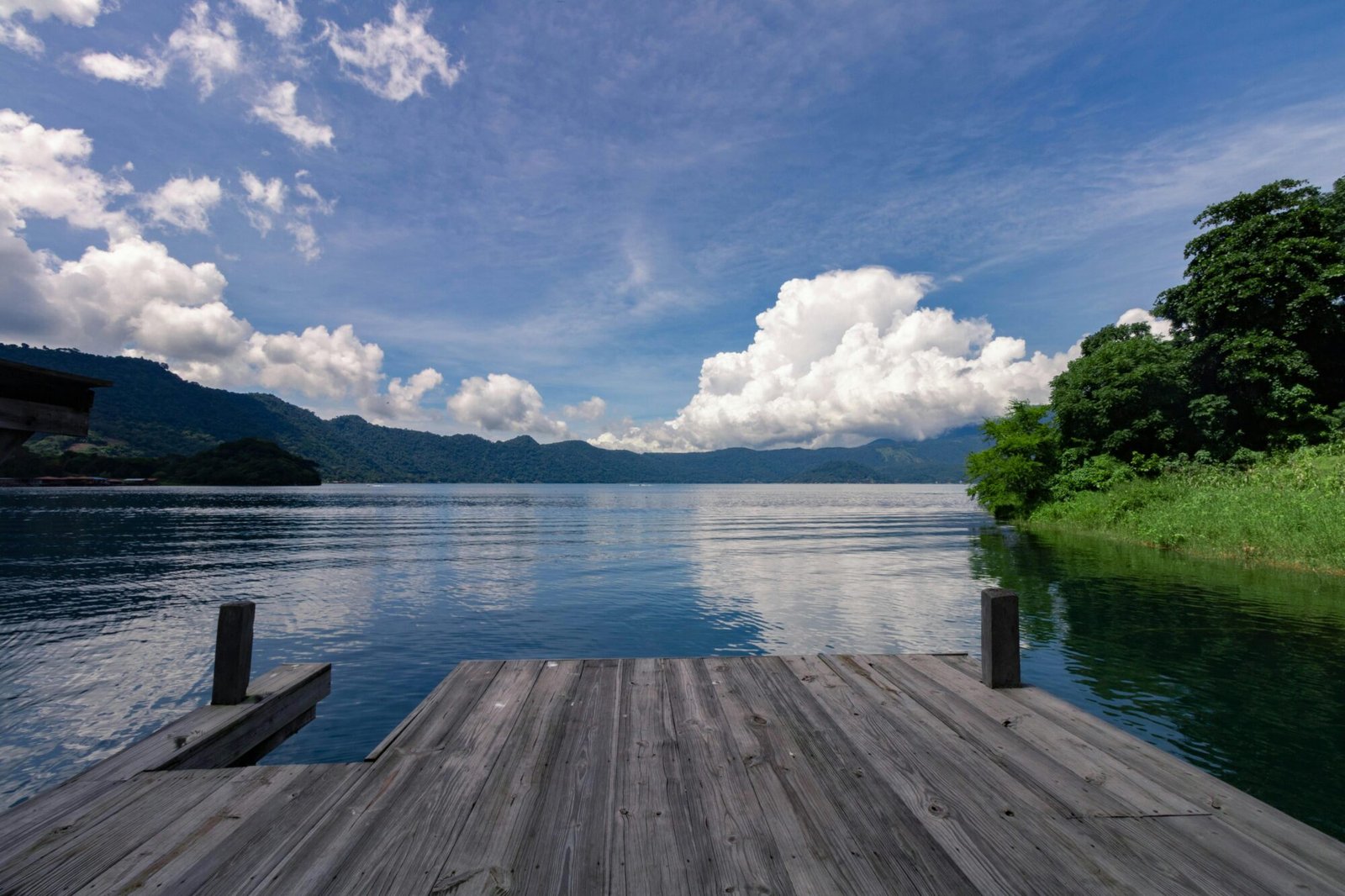 Scenic view of Lake Coatepeque surrounded by lush mountains, near one of the most beautiful cities in El Salvador!