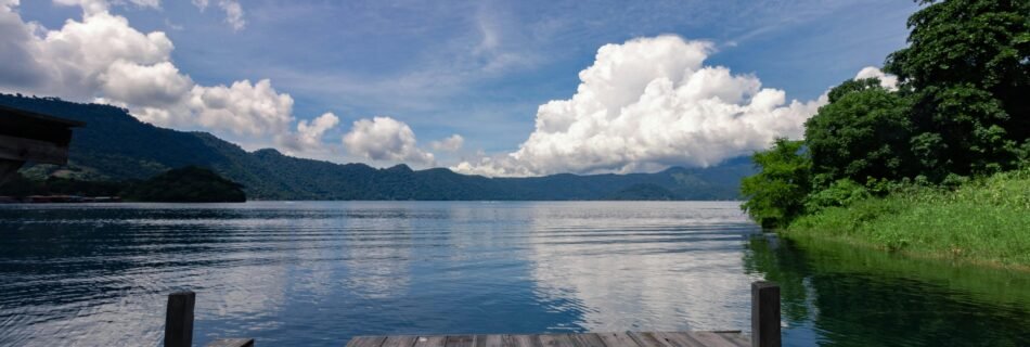 Scenic view of Lake Coatepeque surrounded by lush mountains, near one of the most beautiful cities in El Salvador!