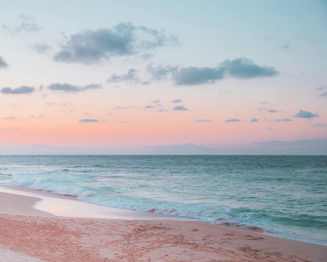 Peaceful sunset at a tropical beach in Honolulu 🇺🇸 with soft pastel skies and gentle waves rolling onto the sandy shore — a dreamy destination for travelers seeking tranquility and natural beauty in the USA.