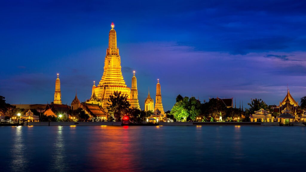 Night view of Wat Arun, the Temple of Dawn, beautifully illuminated on the banks of the Chao Phraya River in Bangkok, Thailand.